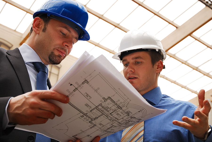 Two construction workers in hardhats looking at blueprints, New Construction Window Installation
