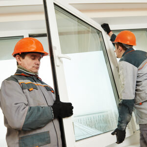 Replacement Window Company vs. DIY, Two male industrial builders workers at window installation