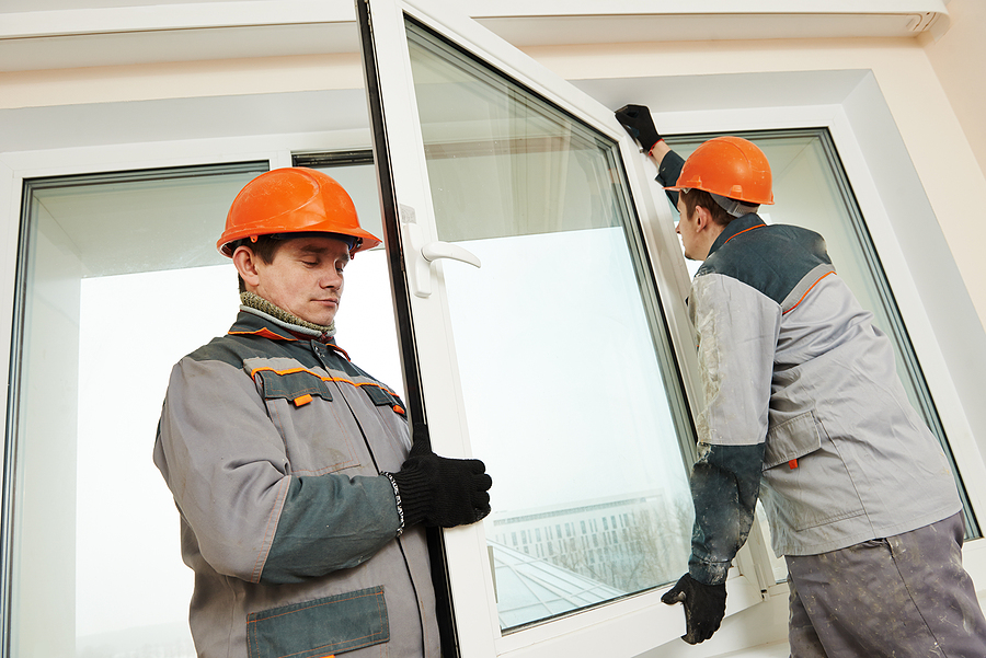 Replacement Window Company vs. DIY, Two male industrial builders workers at window installation